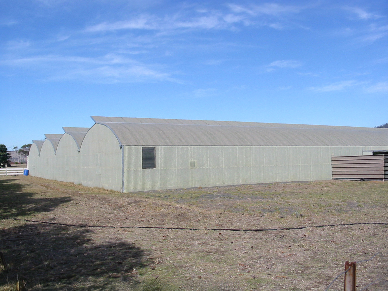 Large industrial structure seen from the side - blue sky - large gravel ground