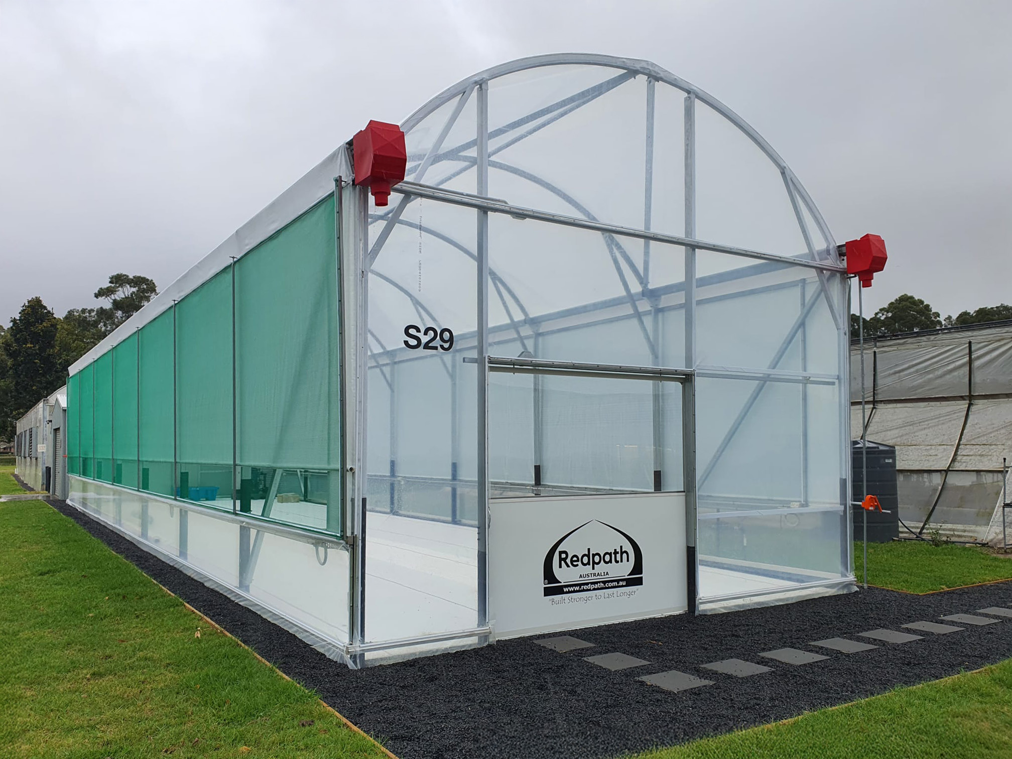 Front and side view of arch greenhouse - redpath logo - green grass surrounding
